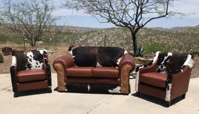 loveseat and chair set in leather and cowhide with tooled arms