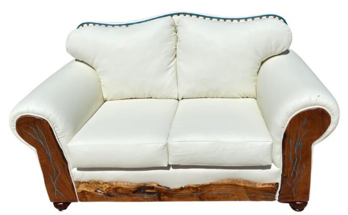 white leather love seat with curved top and decorative tacks
